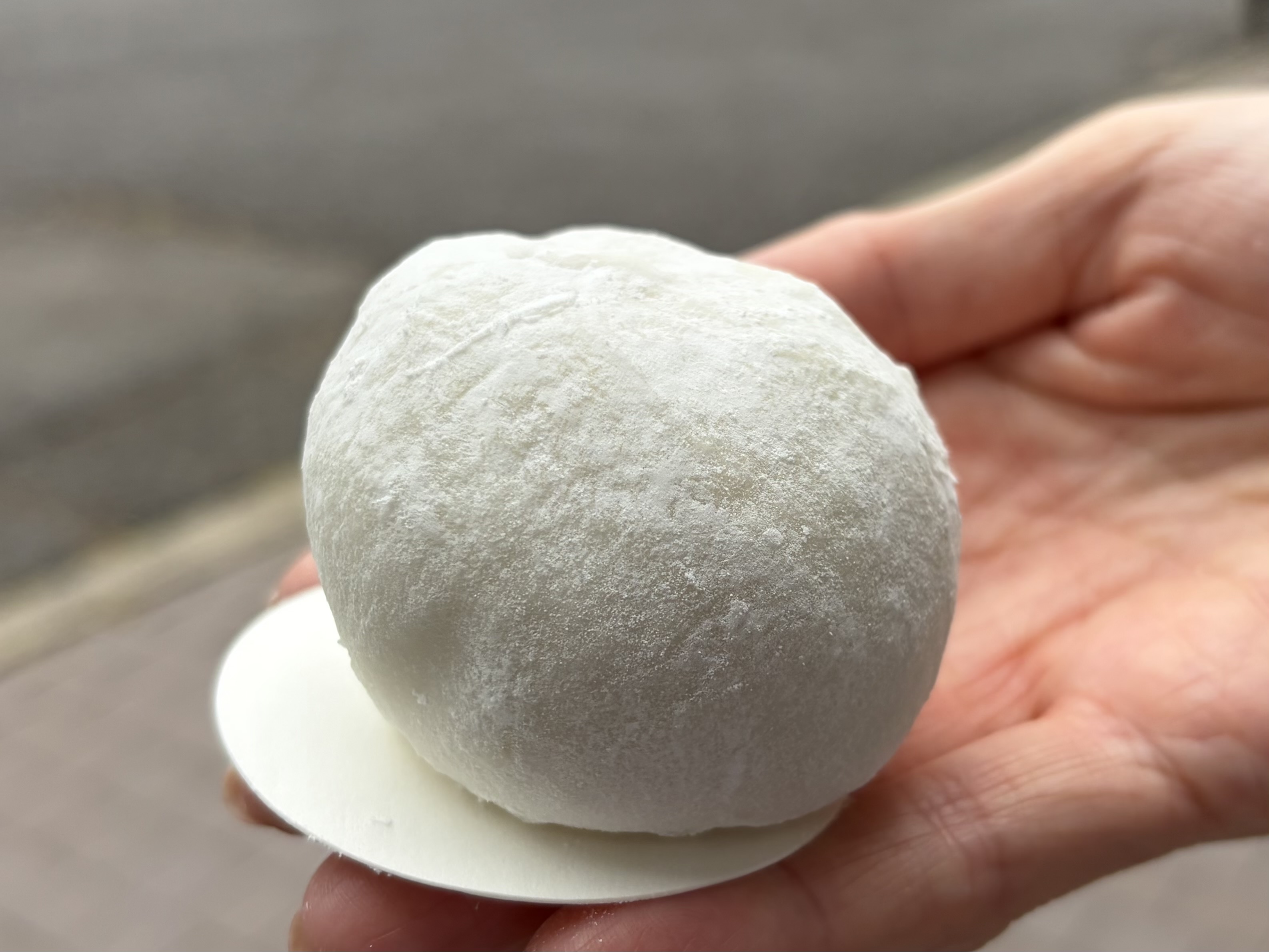 手のひらに載せられた、白い粉をまとった丸い菓子。
